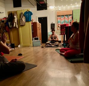 People sit on mats in a room